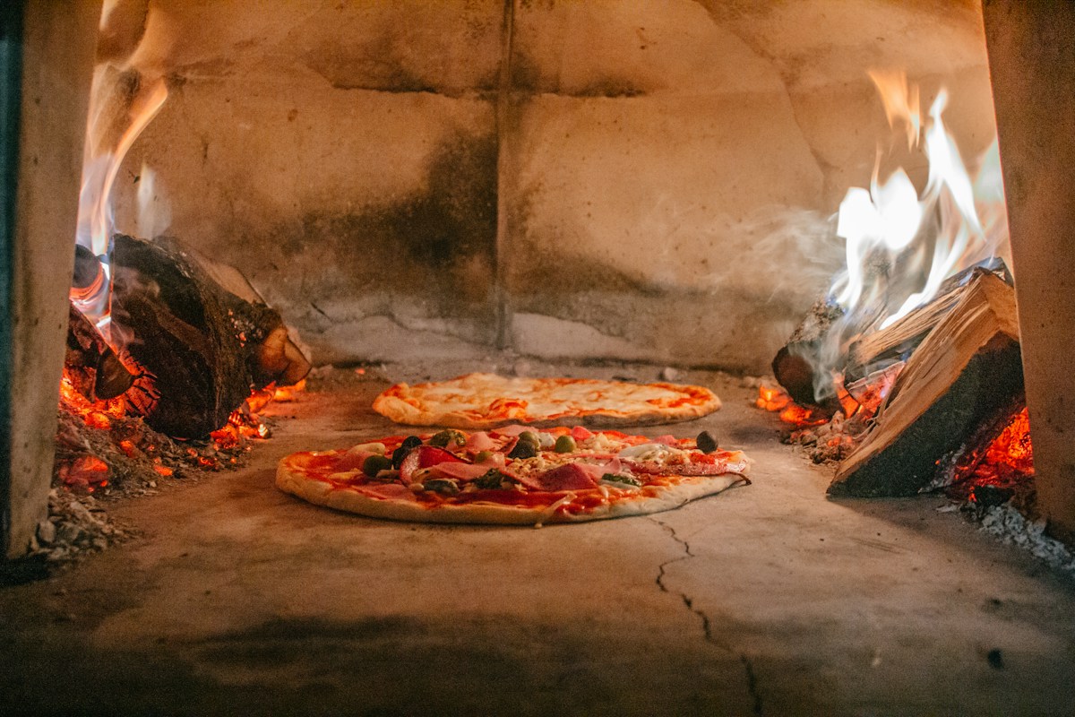 Pizzas dans un four à bois, photographie d’ambiance